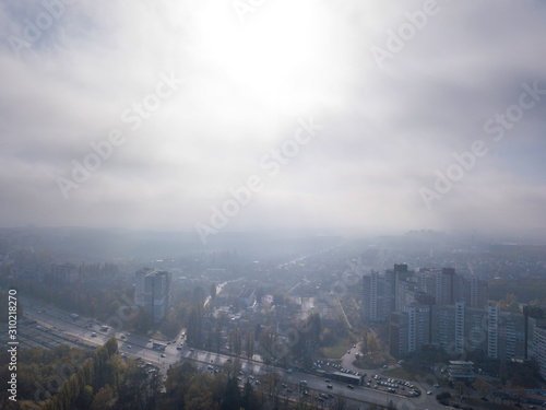 Sunny foggy morning sky above residential areas.