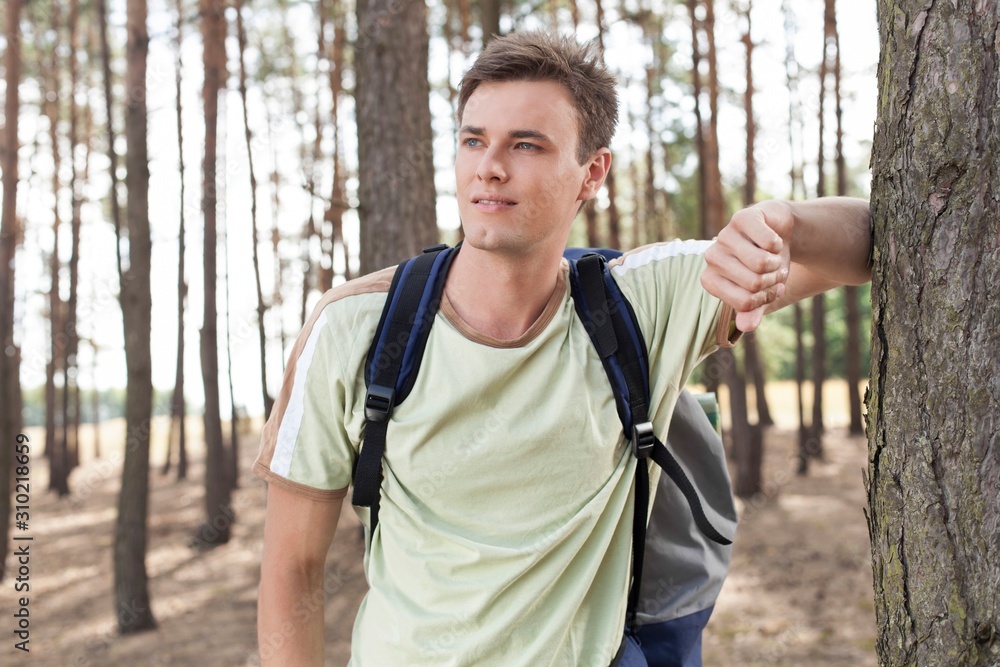 Happy young man with backpack hiking in woods Happy young man with backpack hiking in woods
