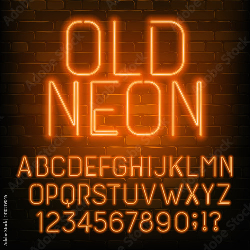 Old Neon alphabet font. Retro orange neon letters and numbers. Brick wall background. Stock vector typescript for your typography design.