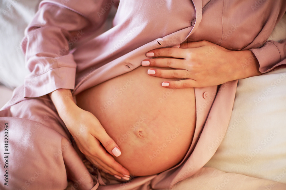 Pregnant girl love her belly in her bedroom. , care, pregnancy