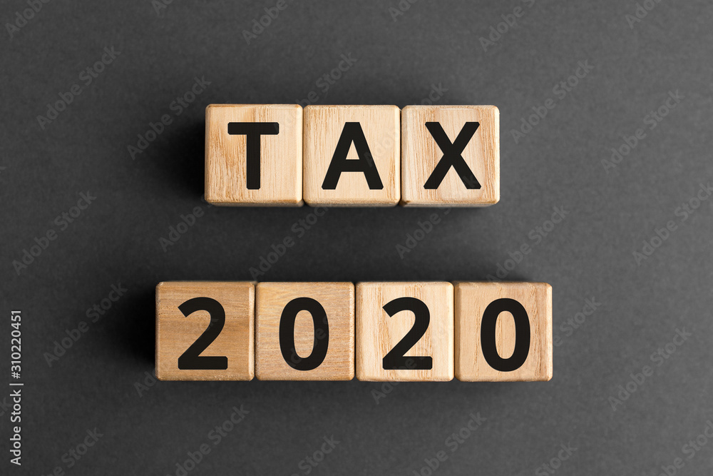 Obraz premium Tax 2020 - phrase from wooden blocks with letters, Tax time 2020 concept, top view gray background