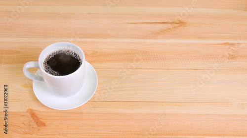 Coffee cup on wooden table background, copy space