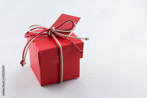 Piccola scatola rossa con fiocco di corda colorata e bigliettino rosso © errem