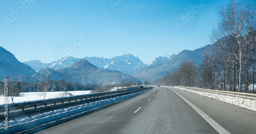 freeway to garmisch with view to zugspitze mass in winter with traffic, bavarian alps
