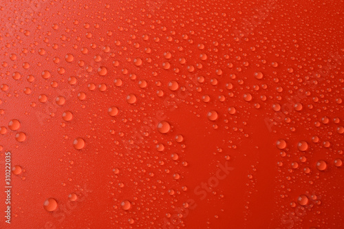 Many water drops on red background. Texture background.