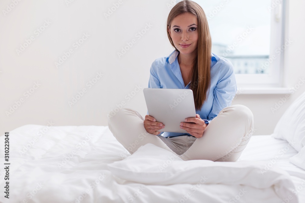 Beautiful woman using tablet computer on her bed Beautiful woman using tablet computer on her bed