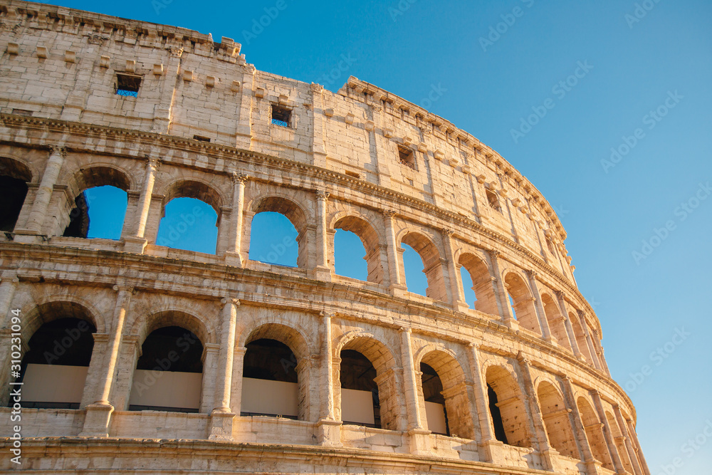 Colosseum or Coliseum ancient ruins background blue sky Rome, Italy