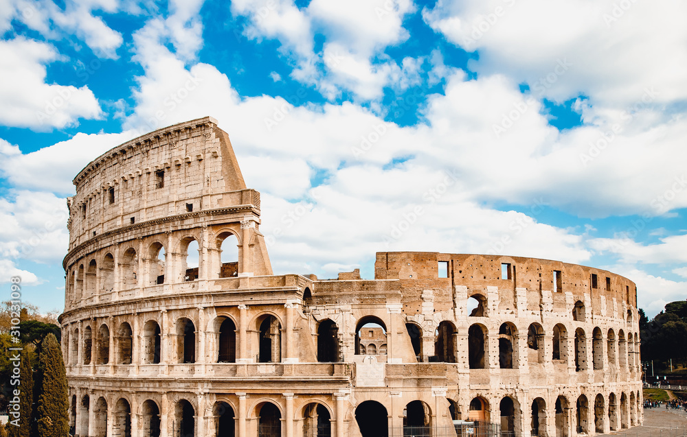 Ancient ruins Colosseum Rome, Italy, background blue sky with clouds
