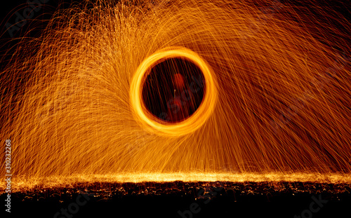 Burning steel wool fireworks spinning in dark night