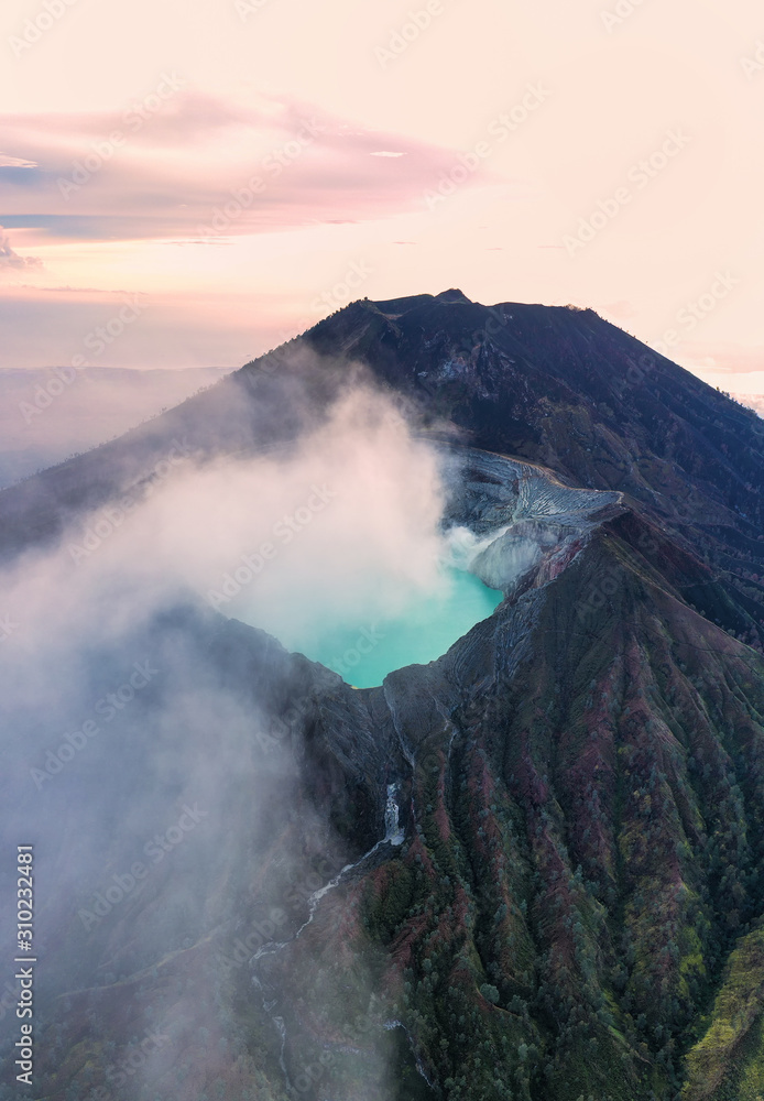 Stunning sunrise over the Ijen volcano with the beautiful turquoise-coloured acidic crater lake. The Ijen volcano complex is a group of composite volcanoes located in Banyuwangi, East Java, Indonesia.