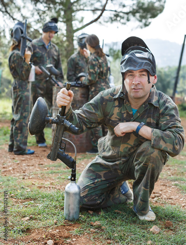 Paintball player in camouflage with gun