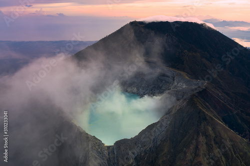 Stunning sunrise over the Ijen volcano with the beautiful turquoise-coloured acidic crater lake. The Ijen volcano complex is a group of composite volcanoes located in Banyuwangi, East Java, Indonesia.