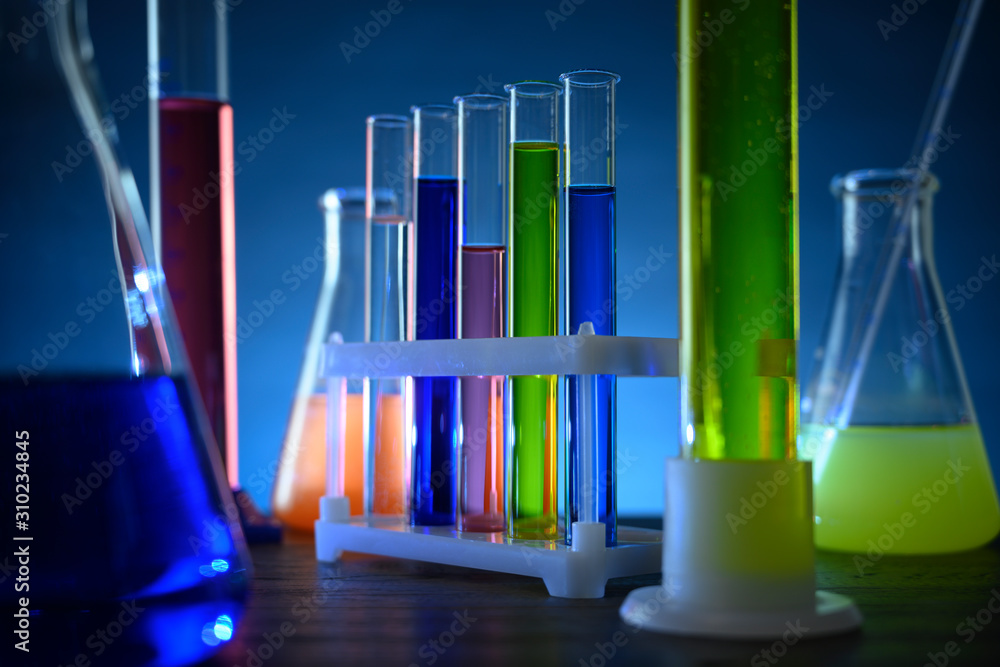 test tubes and flasks with colored liquids stand on a table in a laboratory test tubes and flasks with colored liquids stand on a table in a laboratory