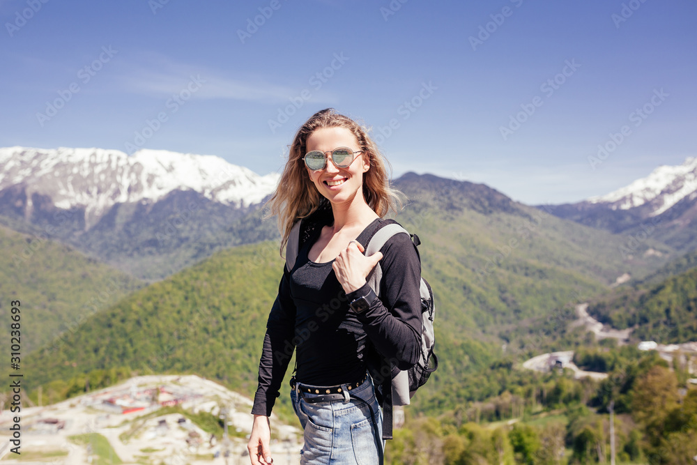 Naklejka premium Portrait of a beautiful young girl lover and protector of the environment and trekking goes to picturesque places in the mountains. Concept of goal achievement and active vacation