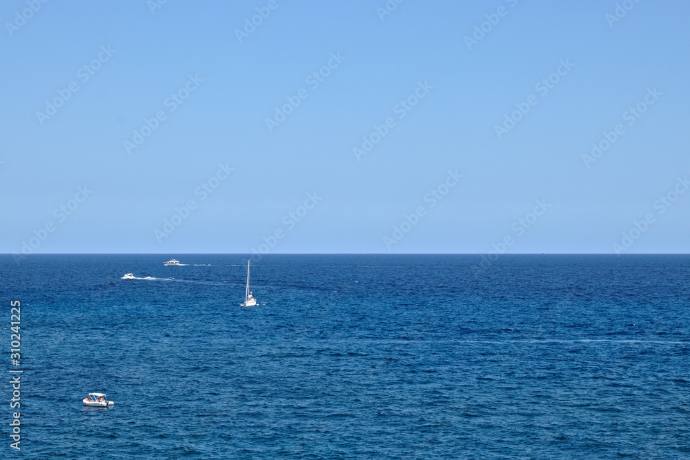 4 boats in the ocean and the horizon in the middle