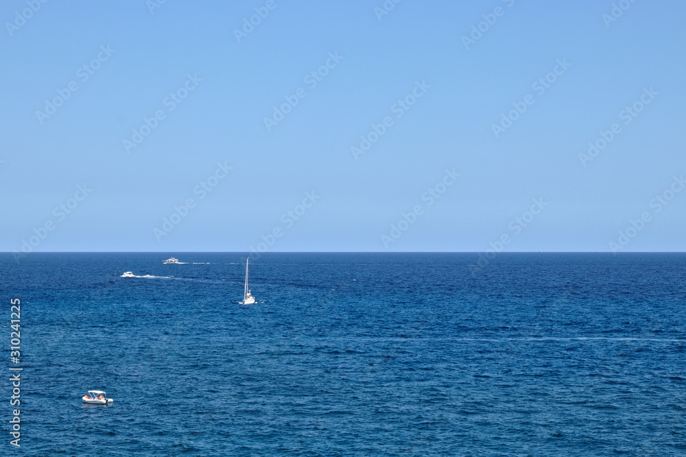4 boats in the ocean and the horizon in the middle 4 boats in the ocean and the horizon in the middle