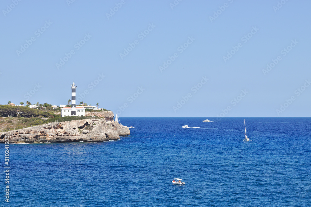 lighthouse next to the ocean with boats