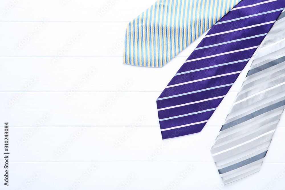 Colored neckties on white wooden table Colored neckties on white wooden table