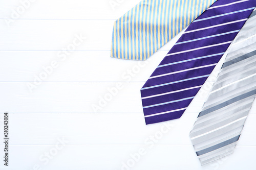 Colored neckties on white wooden table