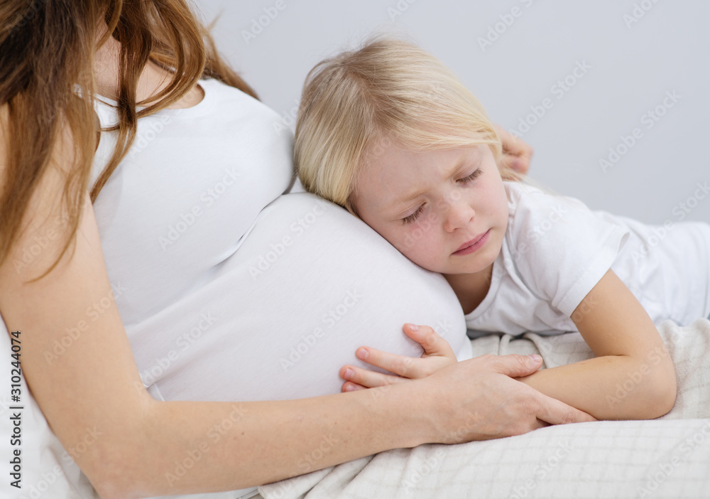 a little girl hugging her pregnant mom a little girl hugging her pregnant mom