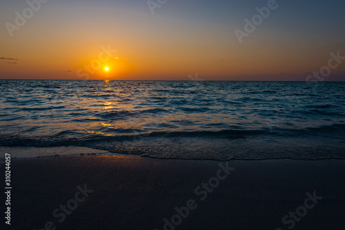 Fototapeta Naklejka Na Ścianę i Meble -  stunning and beautiful sunset on an island with a colorful horizing and the sun setting 