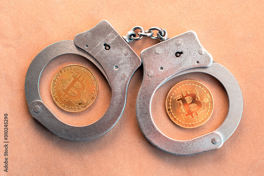 Bitcoins and handcuffs as an abstract symbol of crime that can hide cryptography