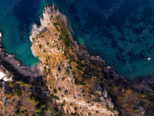 Beautiful top down aerial view of wilderness bay and mountains on sunrise, hiking to a wild beach, tourist destination place for snorkeling and kayaking. Nerano, Massa Lubrense, Ieranto bay, Italy