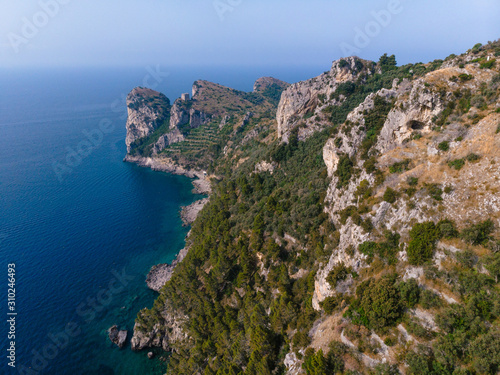 Beautiful aerial view of mountains and sea on sunrise. Marine Park. Trail for active sports, hiking the mountain to a wild beach, Olive trees plantation. Nerano bay, Italy