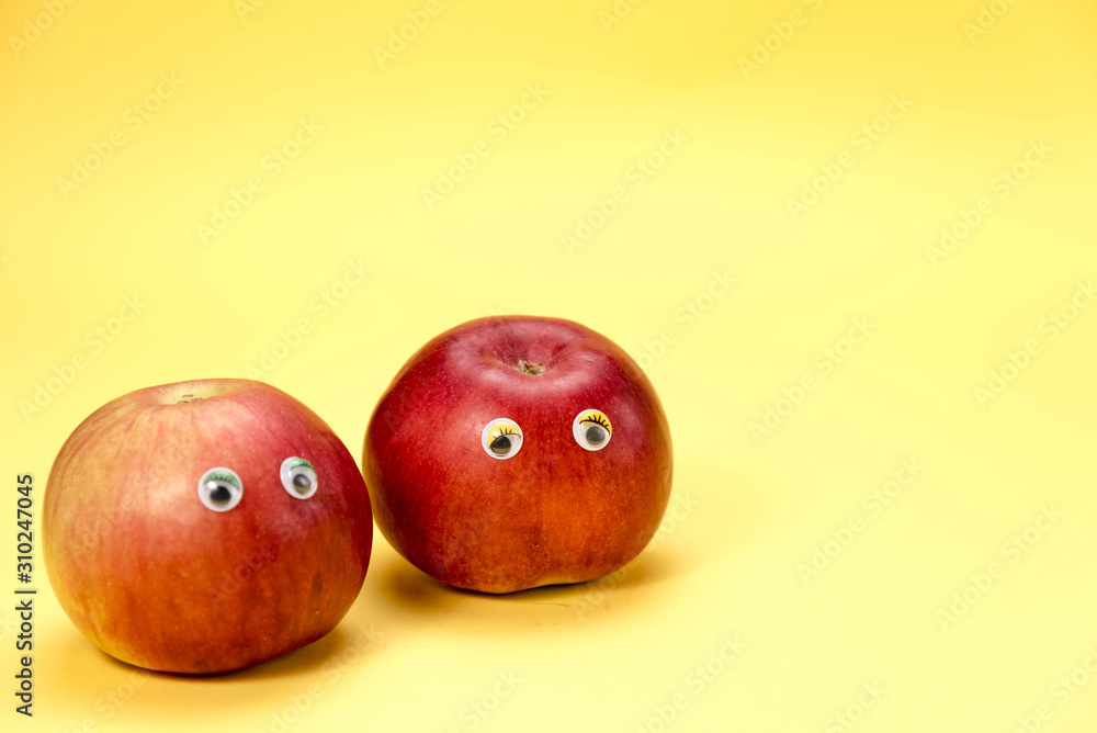 Two Red apple in natural light on yellow background