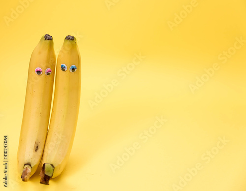Obraz na płótnie Two Bananas isolated on yellow and copy space w salonie