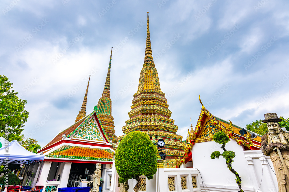 Fototapeta premium Wat Pho temple in Bangkok city, Thailand. View of pagoda and stupa in famous ancient temple. Religious buildings in buddhism style near Grand Palace. Oriental and Asian style, famous tourist target.