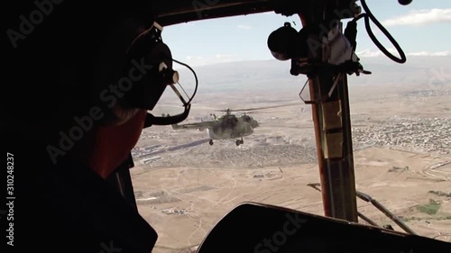 A pair of Russian military helicopters fly on a mission among the mountains