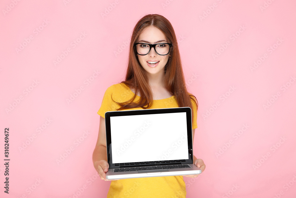 Young woman showing blank laptop screen on pink background - obrazy, fototapety, plakaty 