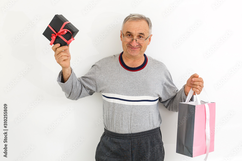 Elderly man holding a box of chocolates ready to give to his wife for Valentine Elderly man holding a box of chocolates ready to give to his wife for Valentine