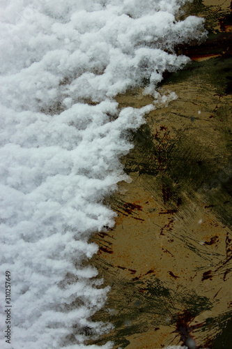 snow on rusty metal surface
