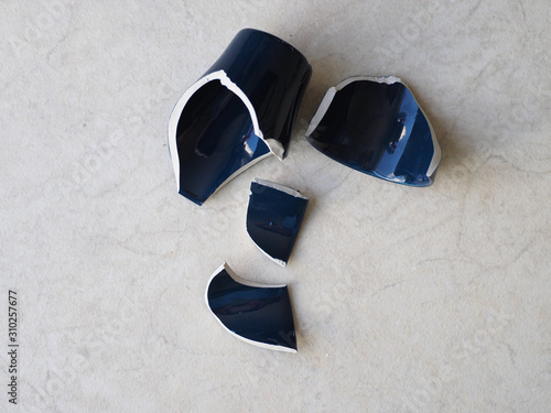 Broken dark blue mug on the floor.