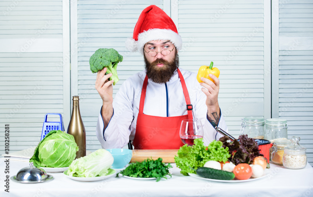 Christmas diet. Enjoy healthy christmas dinner. Healthy christmas holiday recipes. How make your christmas dinner healthier. Man bearded chef wear santa claus hat cooking. How to enjoy holiday meals