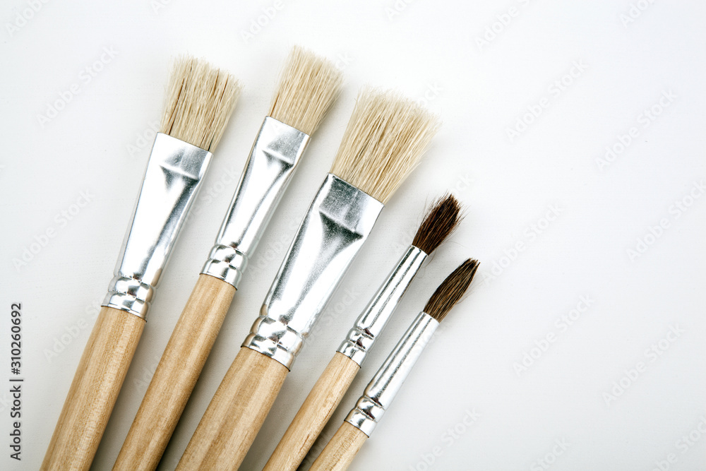 four brushes for painting on a white table