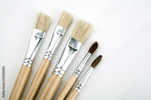 four brushes for painting on a white table