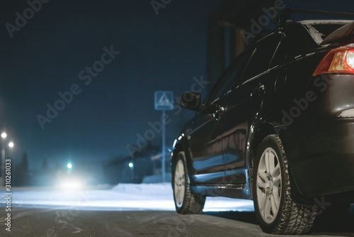 Empty night winter road and a car on roadside. © Dmitriy