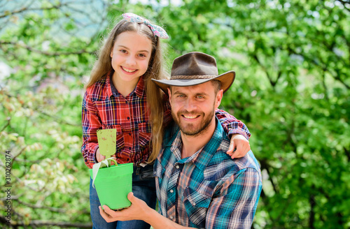 Family dad and daughter planting plants. Plant your favorite veggies. Planting season. Family garden. Transplanting vegetables from nursery or gardening center. Maintain garden. Planting flowers