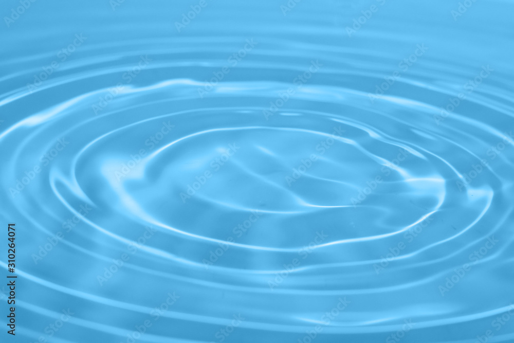 Closeup Water drop falling on the surface of the water and beautiful circular wave ripple, fresh natural mineral water drink water concept Closeup Water drop falling on the surface of the water and beautiful circular wave ripple, fresh natural mineral water drink water concept
