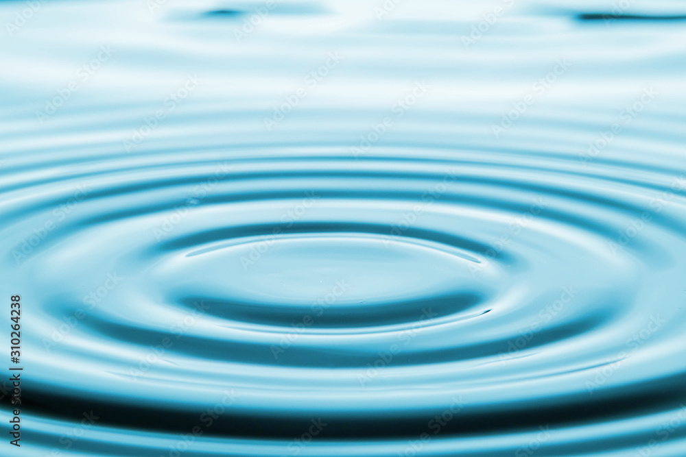 Closeup Water drop falling on the surface of the water and beautiful circular wave ripple, fresh natural mineral water drink water concept Closeup Water drop falling on the surface of the water and beautiful circular wave ripple, fresh natural mineral water drink water concept