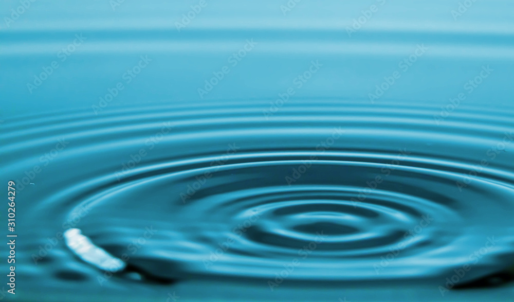 Closeup Water drop falling on the surface of the water and beautiful circular wave ripple, fresh natural mineral water drink water concept Closeup Water drop falling on the surface of the water and beautiful circular wave ripple, fresh natural mineral water drink water concept