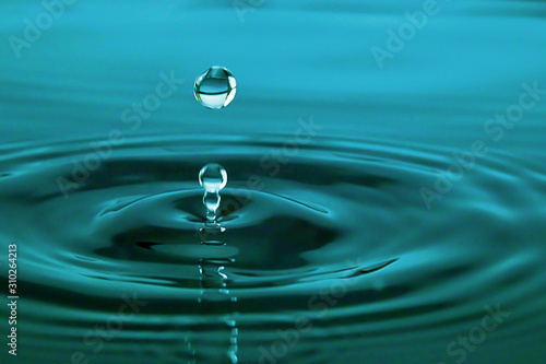 Closeup Water drop falling on the surface of the water and beautiful circular wave ripple, fresh natural mineral water drink water concept