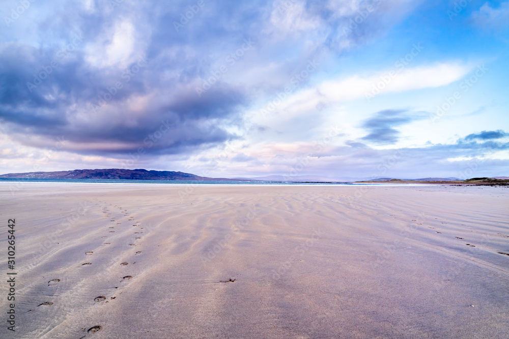 Fototapeta premium Footprints in the sand at sunset in Portnoo, County Donegal - Ireland