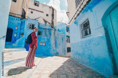 tourist in clothes of the peoples of Asia stands on the street of the blue city of Morocco © nelen.ru