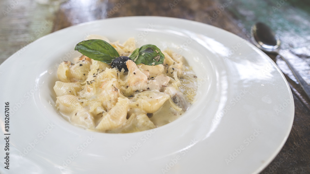 A dish of a pasta with seafood in a white sauce. Close up. A dish of a pasta with seafood in a white sauce. Close up.