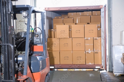 Boxes And Forklift Truck In Warehouse
