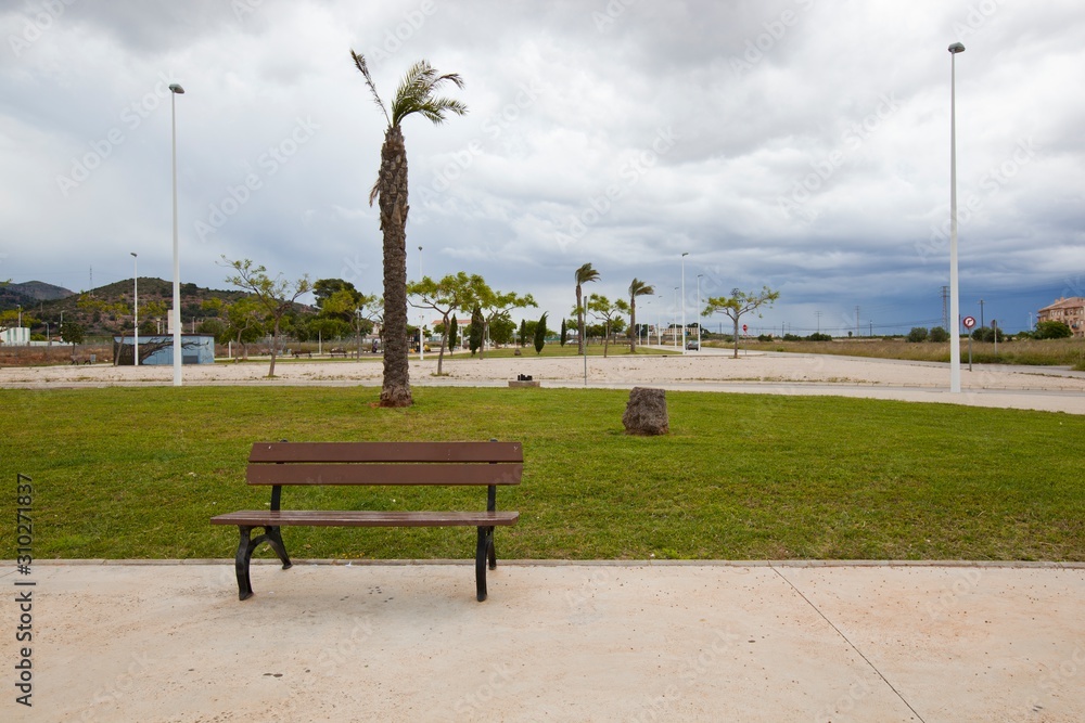 Obraz premium Bench in park with stormy sky, Valencia region, Spain